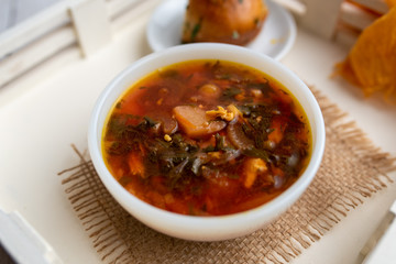 Russian borscht with sorrel and fresh garlic knots pamopushkas. hot soup with egg version. Sorrel soup. 