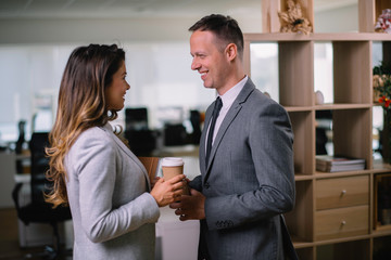Colleagues in office. Businesswoman and businessman discussing work and drinking coffe in office	
