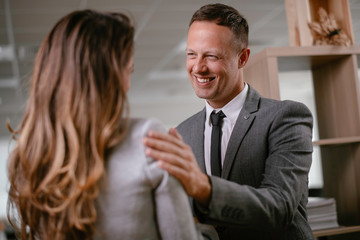 Businessman and businesswoman in office. Young woman and man flirting in office.