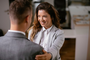 Colleagues in office. Businesswoman and businessman handshake in office.	