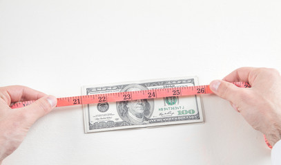 Man with measuring tape and dollars.