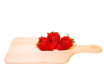 Three red delicious strawberries full size placing together on wooden plate isolated with clipping path