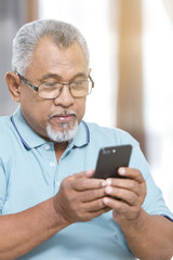 Senior man looking at his phone