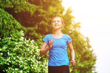 Young fitness woman running at forest trail.