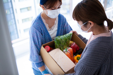 生活物資の配達を受け取る女性