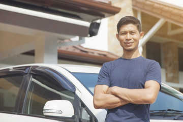 Mid adult man posing with his car