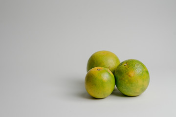THREE PERUVIAN ORANGES FOR JUICE ON WHITE BACKGROUND