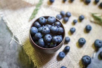 Blueberry antioxidant superfood in a bowl on sackcloth background. Healthy eating and nutrition concept.