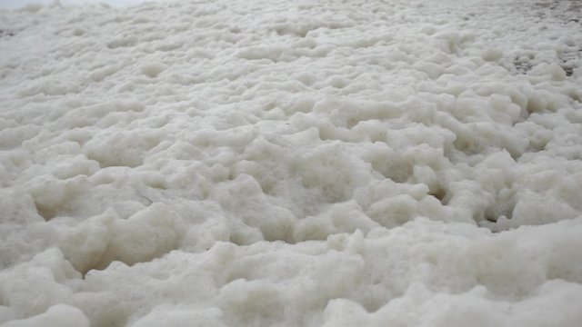 Sea foam washed ashore by the waves during a storm.

