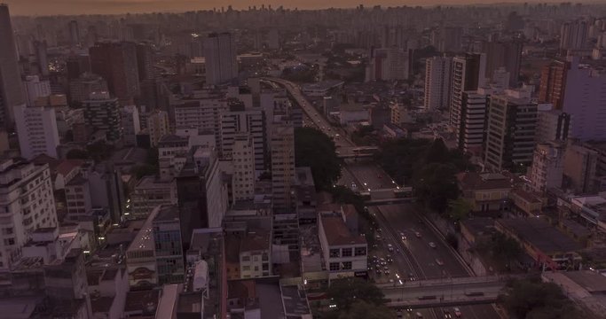 Aerial hyperlapse of sunrise in huge city with heavy traffic. Sao Paulo central area at liberdade neighborhood. Brazil