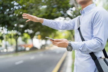Man holding a mobile phone while hailing for a ride