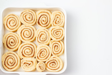 Freshly cinnamon buns with cinnamon and sugar on baking dish. Top view
