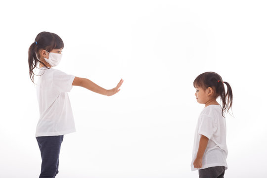 Social distance concept. Two Asian kids wearing mask standing distance of 2 meter from other people keep distance protect from COVID-19 and The risk of infection to others.