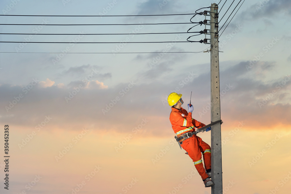 Wall mural Electricians are climbing on electric poles to install and repair power lines.electricians work with high voltage electricity.