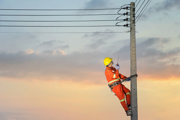 Electricians are climbing on electric poles to install and repair power lines.electricians work...