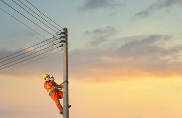 Electricians are climbing on electric poles to install and repair power lines.electricians work...