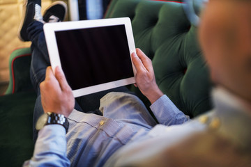 Man using a digital tablet on a couch