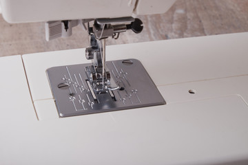 sewing machine with colored thread and needle, on the desktop.