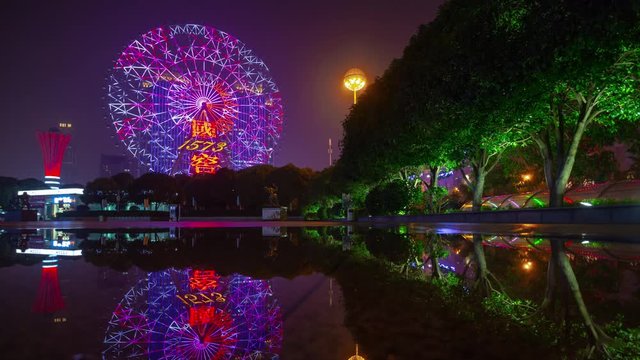 night time illuminated changsha city famous ferris wheel park water reflection panorama timelapse 4k china