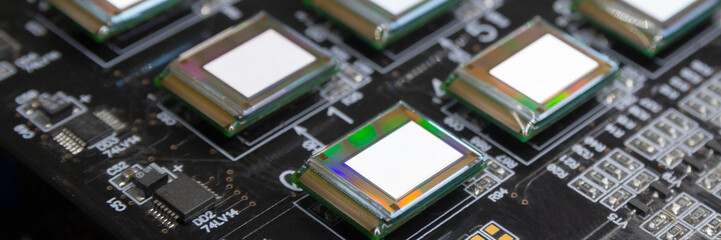 Several microdisplays bright of white color on the test station. Monitors glow brightly of white color close up.Rainbow on surface.