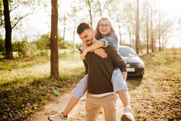 Fototapeta premium Couple walking in the woods, in the background you can see the car