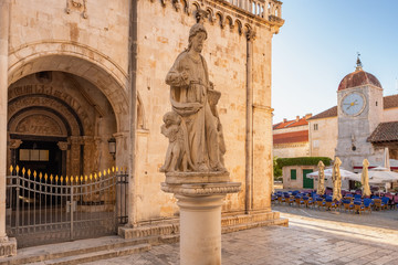 Obraz premium Statue of St Lawrence with Clock tower at background in Trogir, Croatia