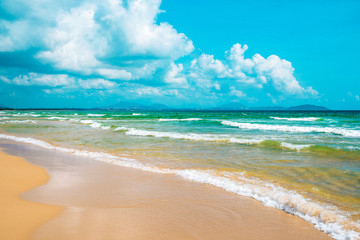 Fototapeta na wymiar Beautiful seascape. Yellow sand beach, azure sea and blue sky with beautiful clouds. South China Sea. Hainan paradise island, Sanya city. Beach Haitang Bay. Shot as a wide plan. 