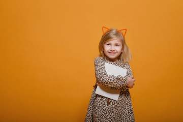 funny girl in leopard dress on yellow background with notebook in hands