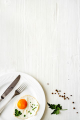 Fried eggs on plate - white wooden dinner table from above copy space
