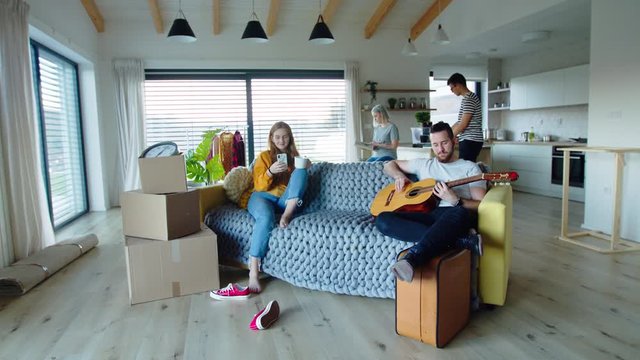 Group of young people with guitar moving in new home, house sharing concept.