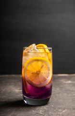 Gin based colorful cocktail with lemon and lavender liqueur on the rustic background. Selective focus. Shallow depth of field.