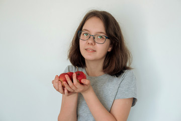 red apples and a teenager in his hands. Vegetarianism and vitamins for children. Good nutrition