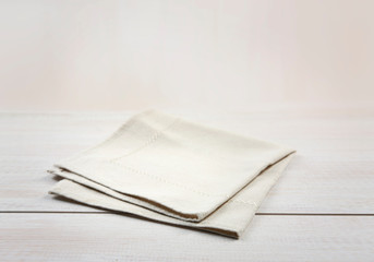 Soft beige folded kitchen towel on wooden table empty copy space.Food advertisement backdrop.