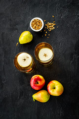 Fruit drinks with apple and pear on black background from above