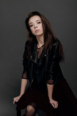 fashion model woman in a black jacket on a gray background