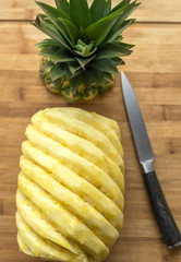 Ripe perfectly peeled pineapple, on a wooden background.