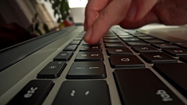 Female pressing buttons of laptop typing text to code a software application. Entering log-in and password information. Macro slider shot, 4K