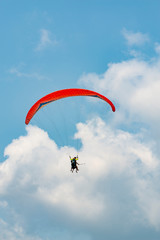 Manned paraglider flying in the blue sky