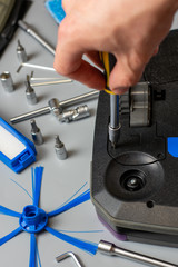 A man is fixing robot vacuum cleaner by hand holding screwdriver to open the cover. Consumables for a robot vacuum cleaner.