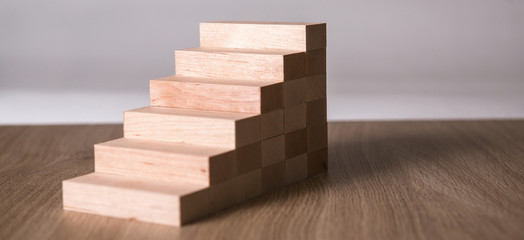 Wooden blocks in shape of a staircase as step for success in business.