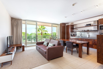 Modern furnished living room with integrated kitchen, terrace, overlooking the nature.