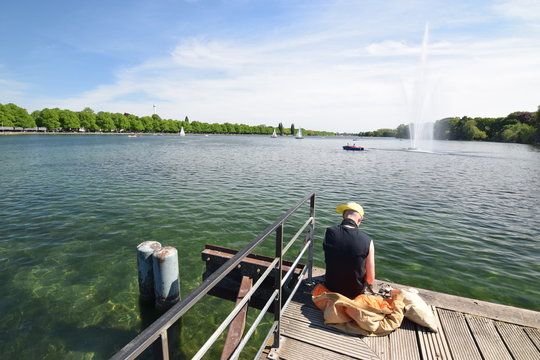 Junger Mann sitzt einsam am Maschsee in Hannover