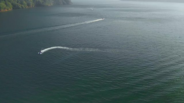 Epic aerial of a speed boat leaving Scotland bay on the Caribbean island of Trinidad