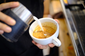 Barista making a cup of coffee latte art.