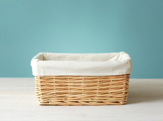 Empty straw basket with white linen on wooden table.Empty food container.