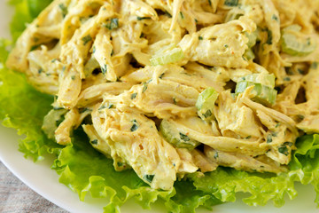 Homemade Coronation Chicken Salad on a white plate, low angle view. Close-up.