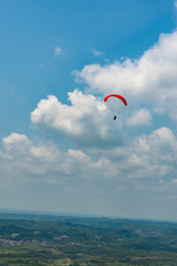 Outdoor city green hill scenery and paragliding