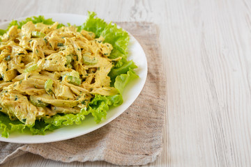 Homemade Coronation Chicken Salad on a white plate, low angle view. Copy space.