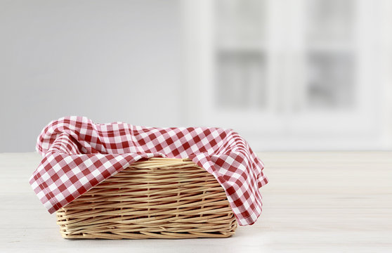 Empty straw basket with red checkered picnic cloth empty space food advertisement design.