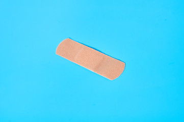 Sticky medical patch on blue background. Healthcare concept